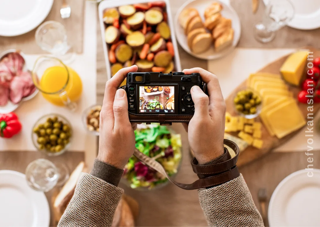 A person photographing a table filled with different dishes